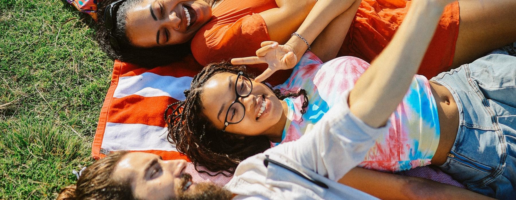 a group of people lying on blankets in a park