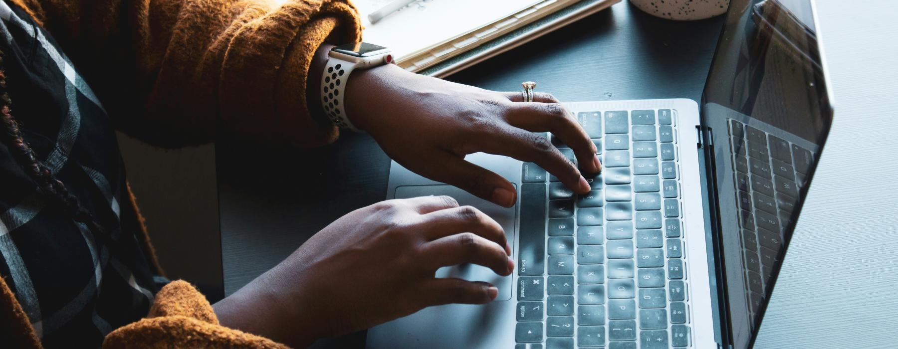 a woman typing on a laptop