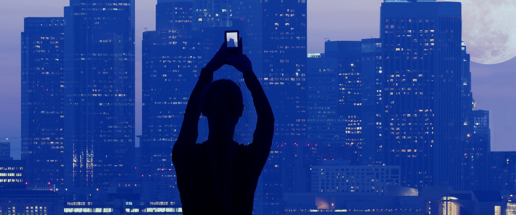 a person taking a picture of a skyline