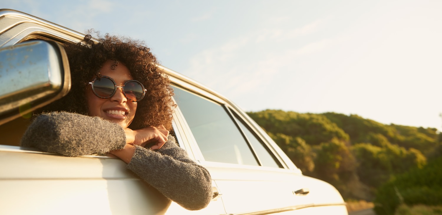 a woman leaning out of a car smiling
